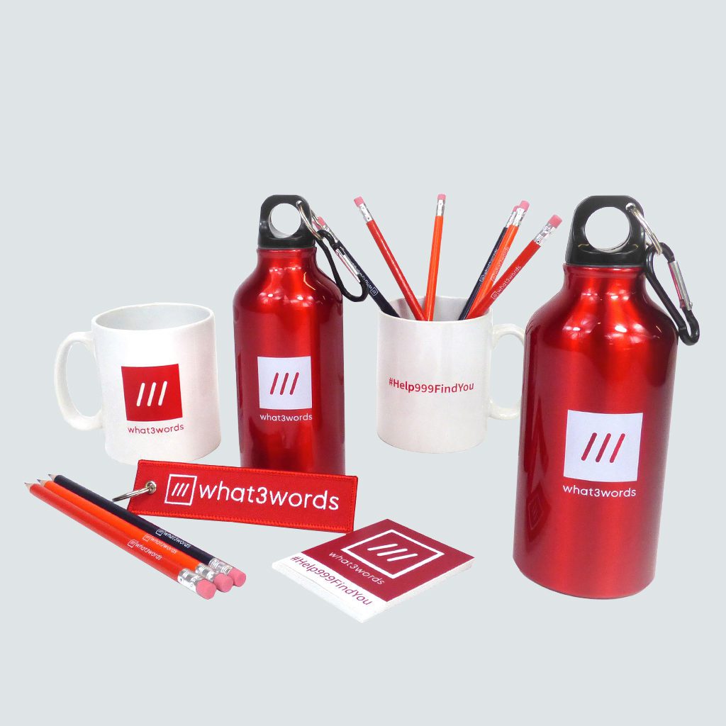 collection of red and white branded merchandise over printed with What3Words logo